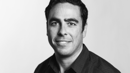 black and white headshot of man with dark short hair and dark collared shirt